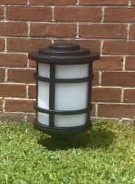 A light on the grass with a wall in the background