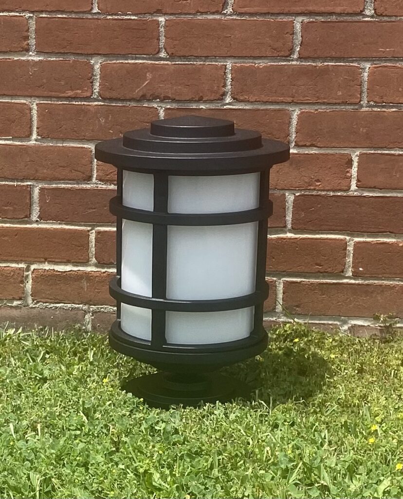 A light on the grass with a wall in the background